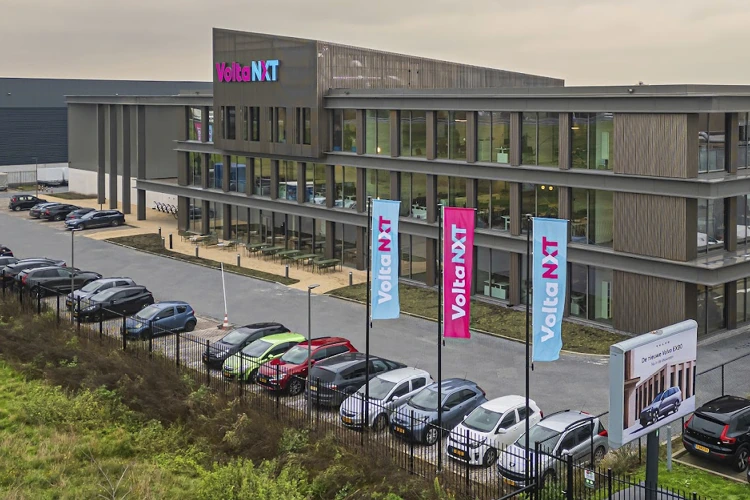 Droneshot van het bedrijfspand van Volta NXT waarbij de vlaggen met het logo duidelijk zichtbaar zijn.