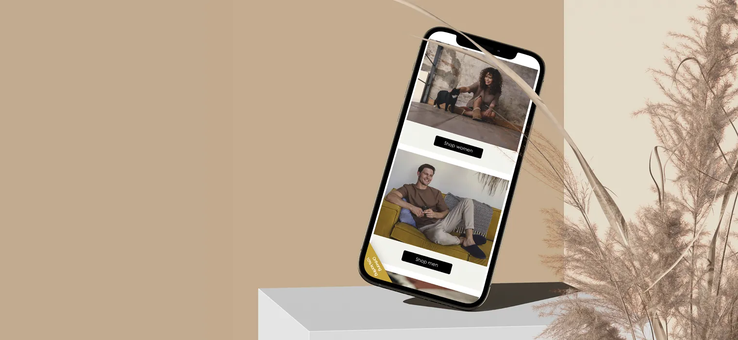 Mobiel met de homepage van Greve op het scherm, balancerend op een blok.
