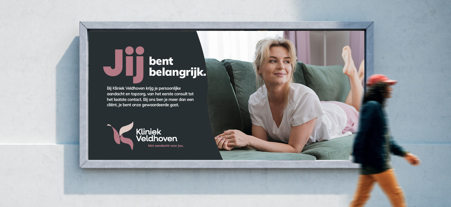 Reclameposter van Kliniek Veldhoven op een muur, met de tekst
